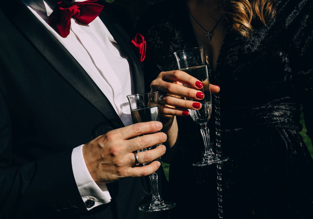 Mann im Smoking und Frau mit Sektglas – Szene eines eleganten Abends im Rahmen von Escort Werden